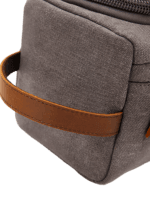 Trousse de toilette homme en toile avec empiècements cuirs et pochette extérieure couleur unie détails anse Trousse de toilette homme en toile avec empiècements cuirs et pochette extérieure couleur unie détails anse